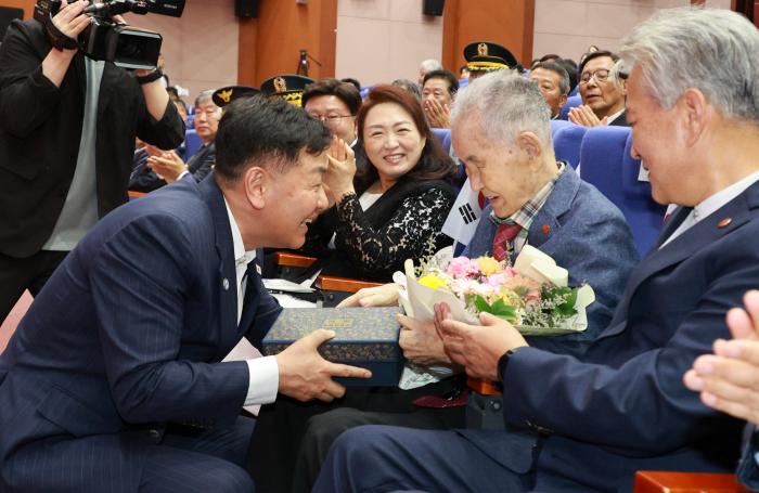 김관영 도지사가 제80주년 광복절 경축식에서 애국지사 이석규 선생에게 꽃다발과 위로물품을 건네고 있다